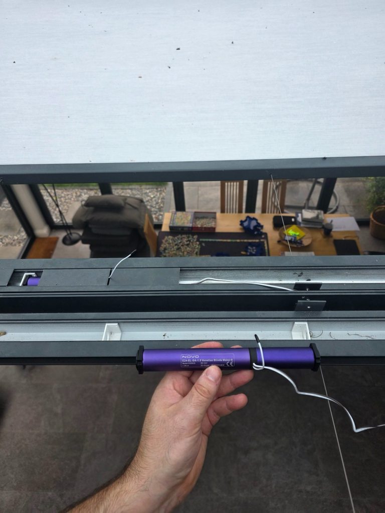 Replacement tubular motor with built-in receiver being fitted to an existing motorised roof lantern blind during repair.