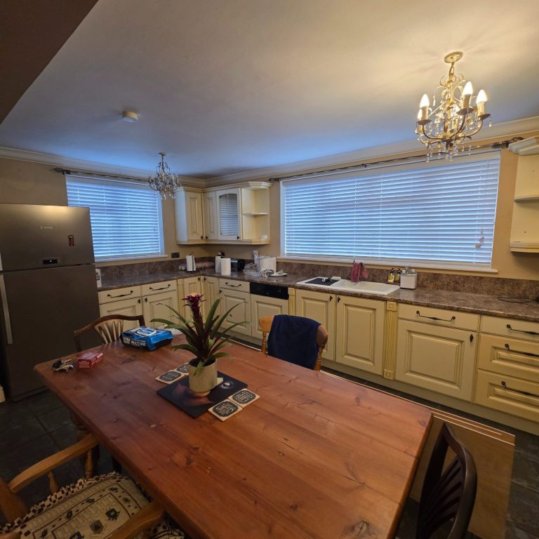Fauxwood Venetian blinds fitted in a classic farmhouse kitchen to provide a clean, practical finish with easy light control
