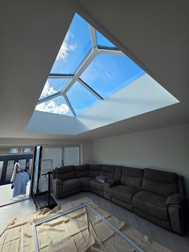 Made-to-measure solar powered roof lantern blind being assembled in a Corby living room, with protective floor coverings laid during install